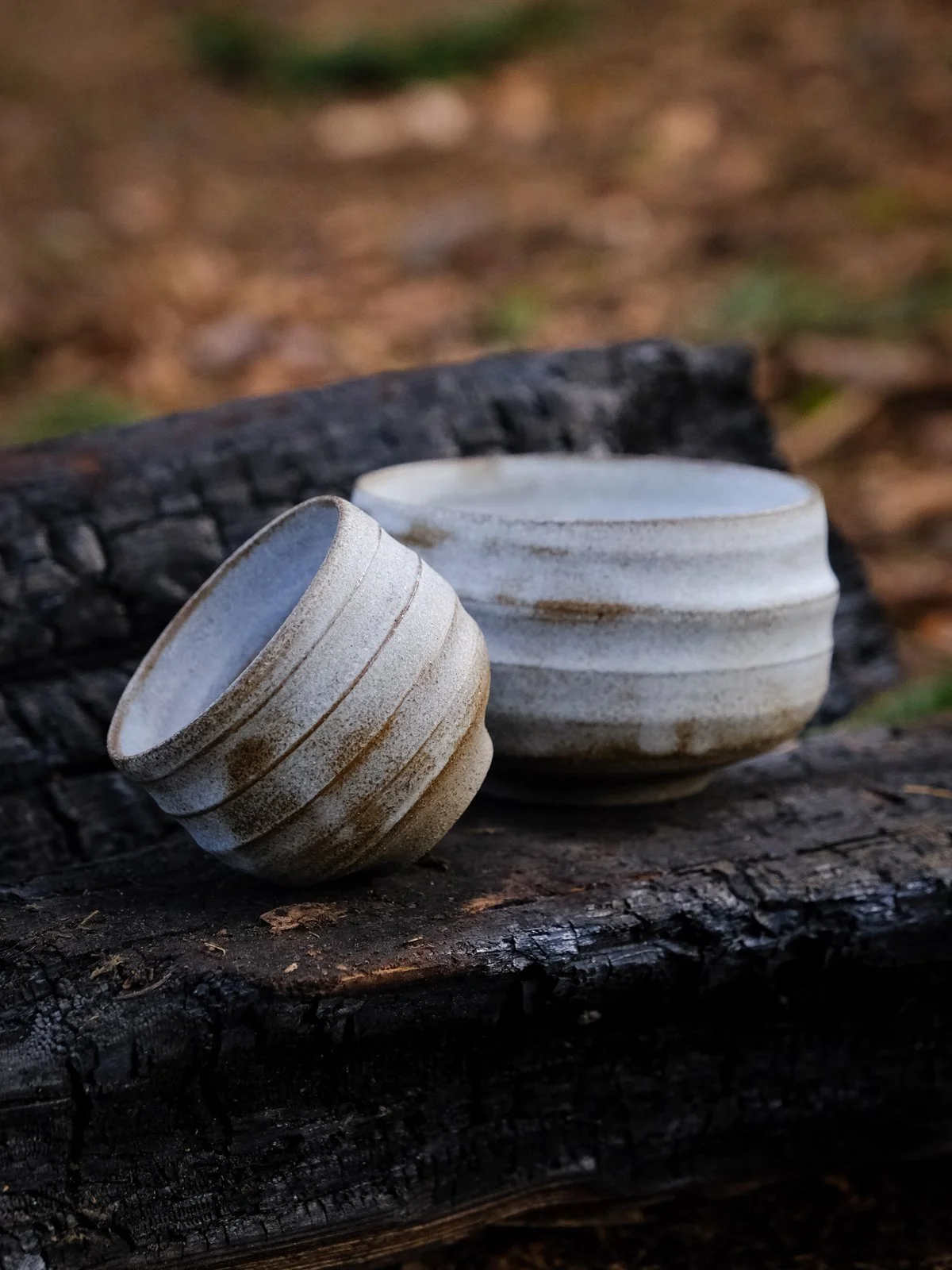 A cup and a matcha chawan featuring organic rustic look in a natural setting.