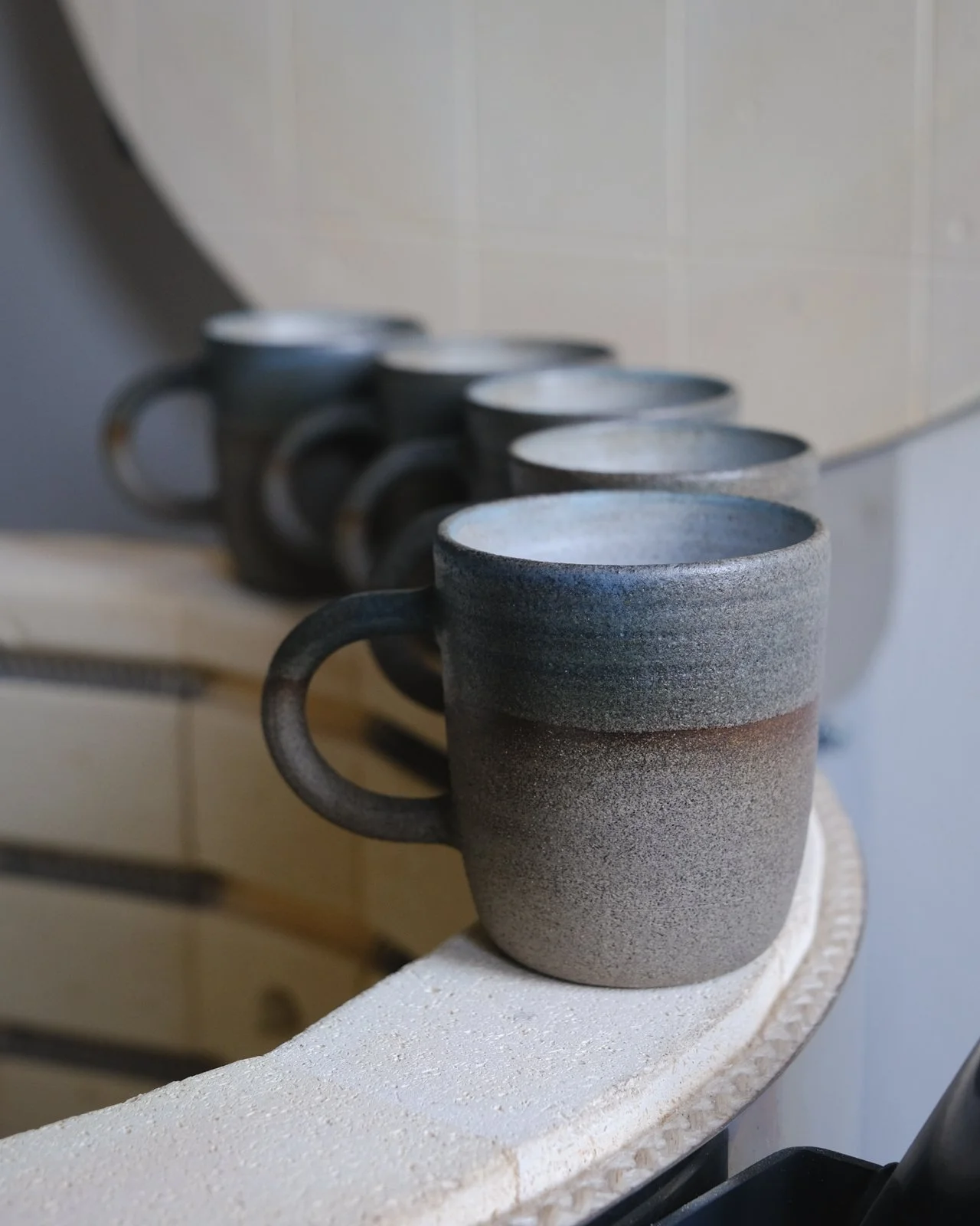 Earthy coffee cups with unglazed stone-grey clay and 2 earthy tones variations.