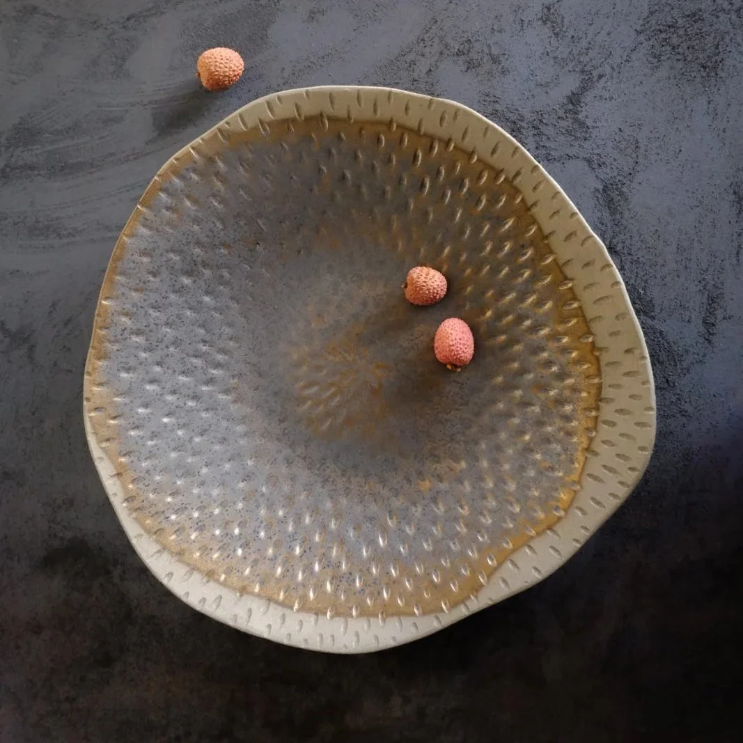 Handmade stoneware organic carved bowl with rustic gold finish and earthy unglazed rim.