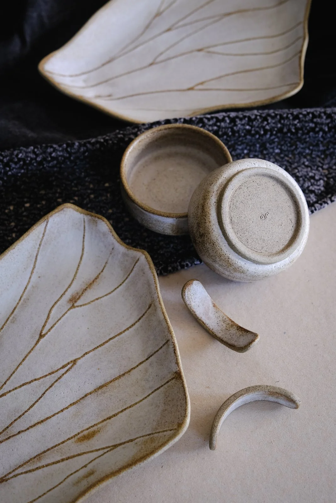 Wing-shaped organic sushi plates, soy sauce bowls and chopstick rests in off-white.