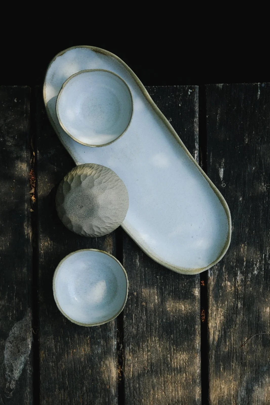 The tapas set Earth presenting organic earthy bowls and a plate with a soft off-white finish.