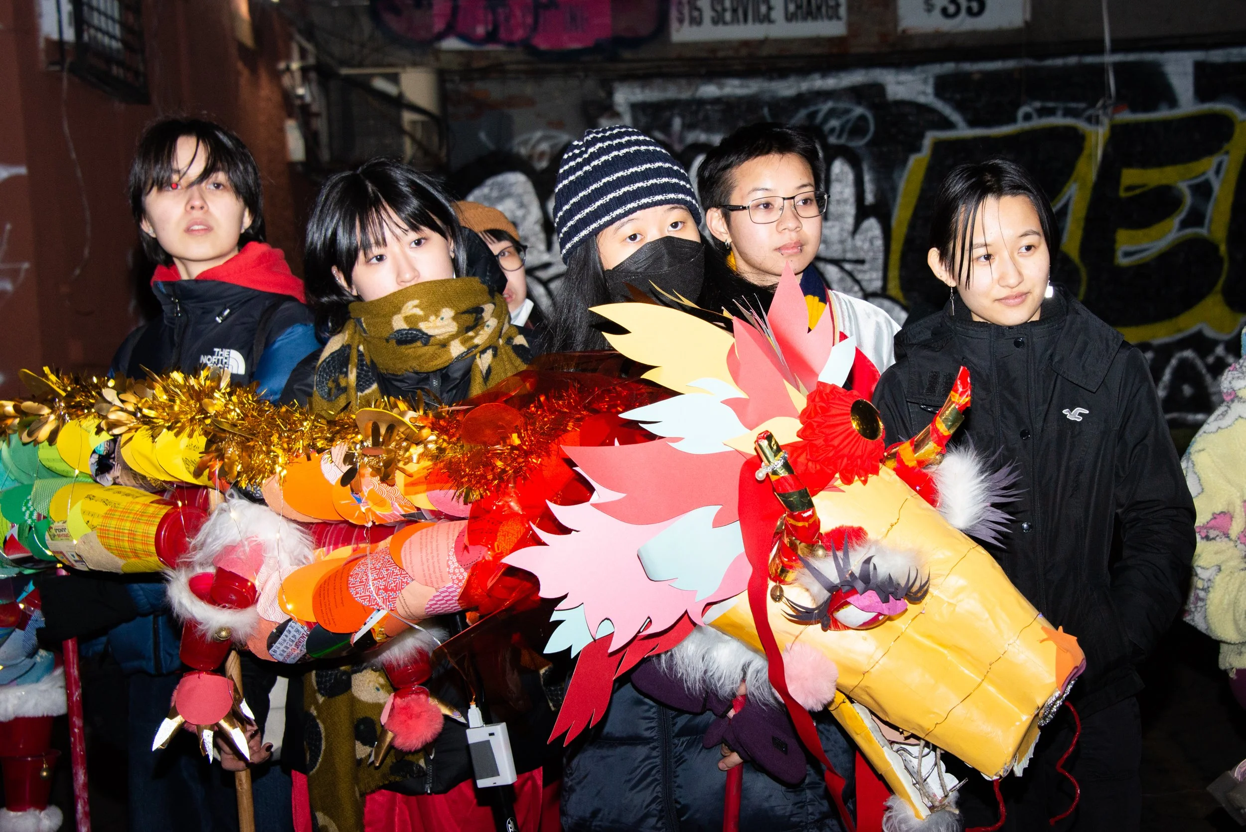 Group of young people at night with Chinese dragon costume for a celebration or parade