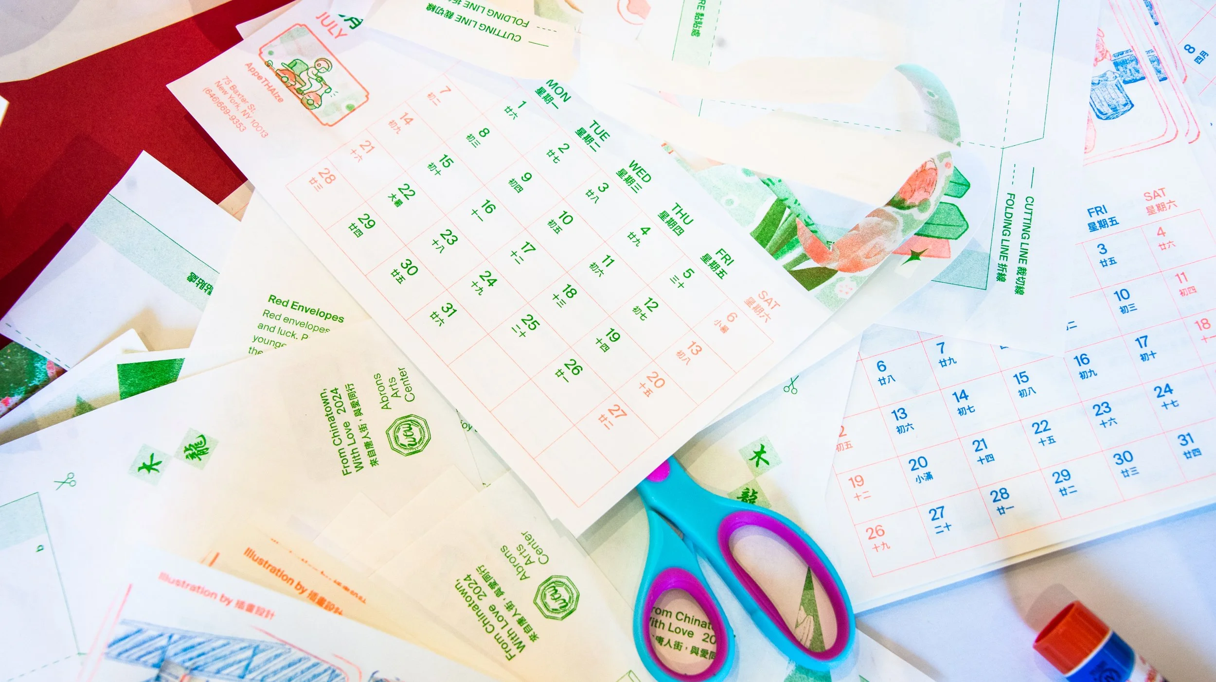 Colorful calendars, scissors, and glue stick on a craft table