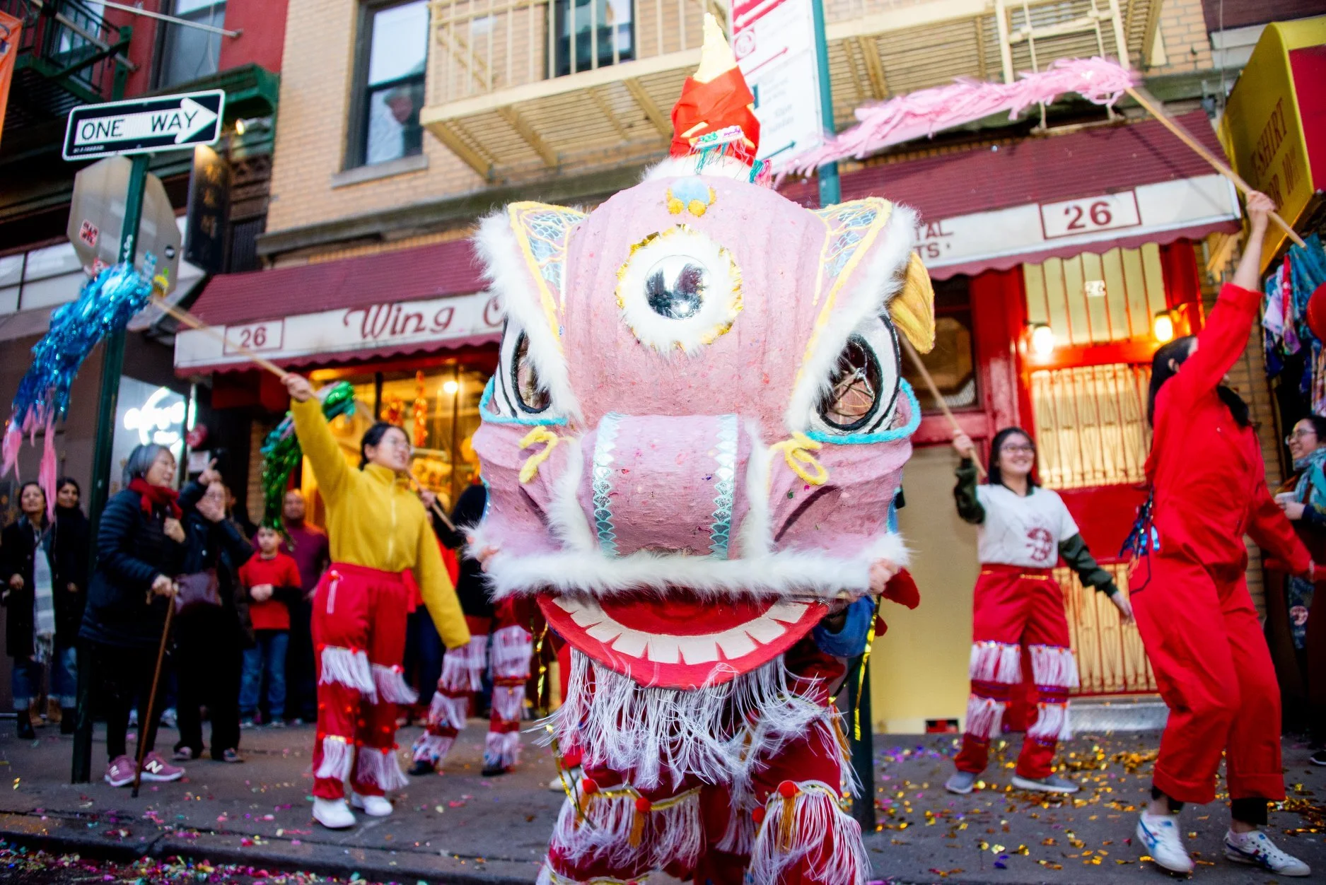 People celebrating with a traditional Chinese dragon dance during a festival on a city street.