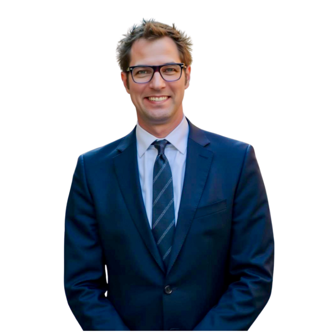 Smiling man in glasses wearing a blue suit, white shirt, and striped tie.