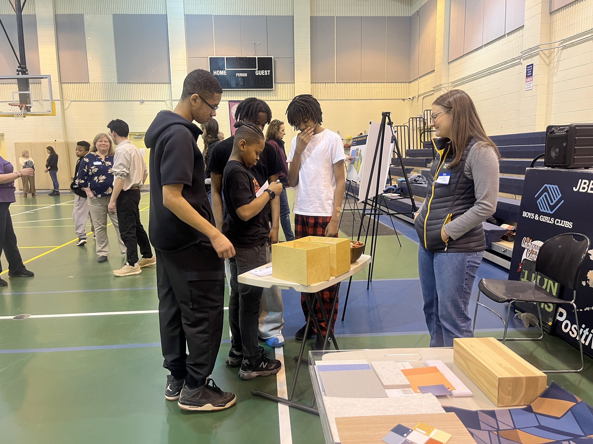 Photo of students and designer at open house.