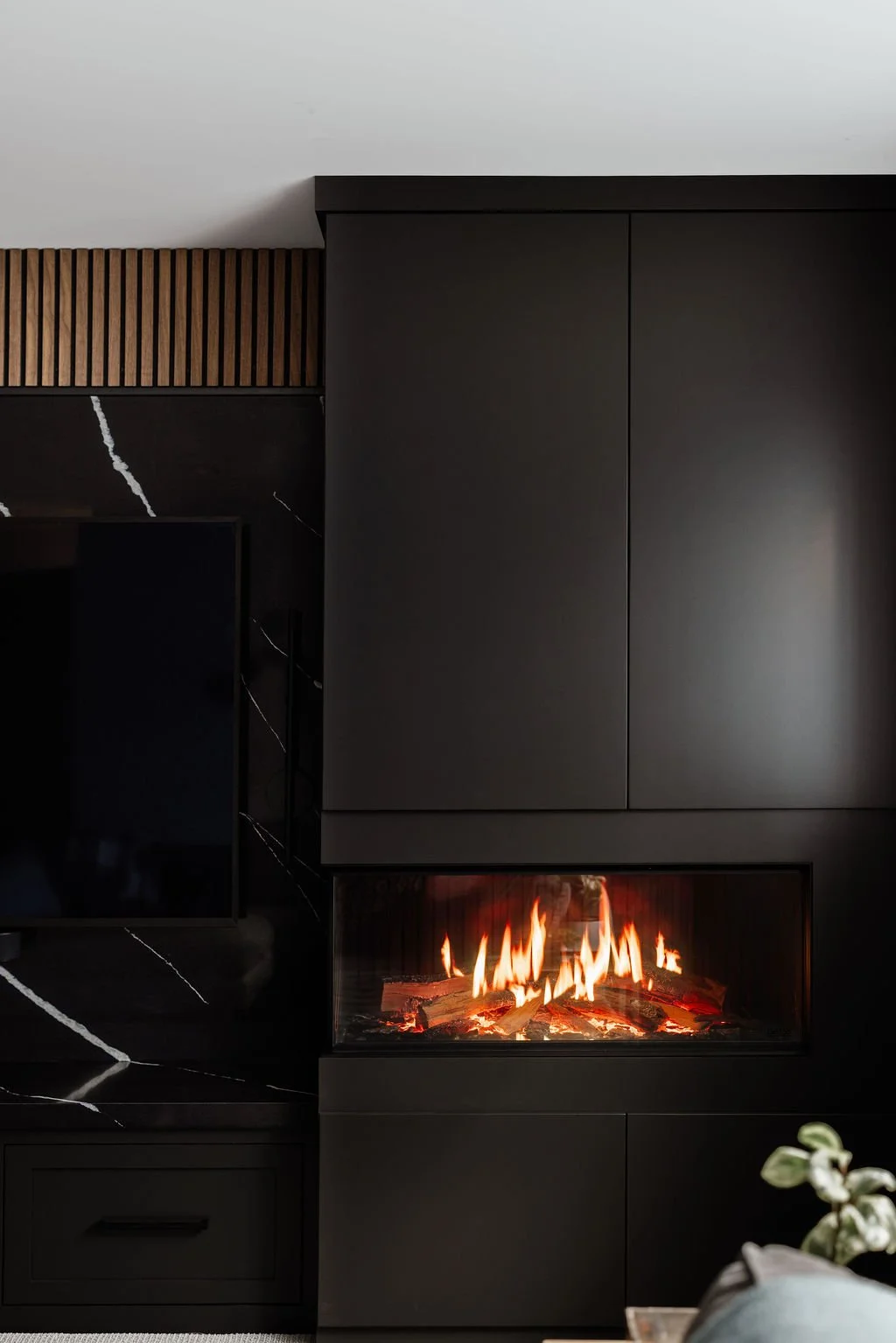 Zoomed in view of the dark cabinetry and the front of the holographic electric fireplace. 