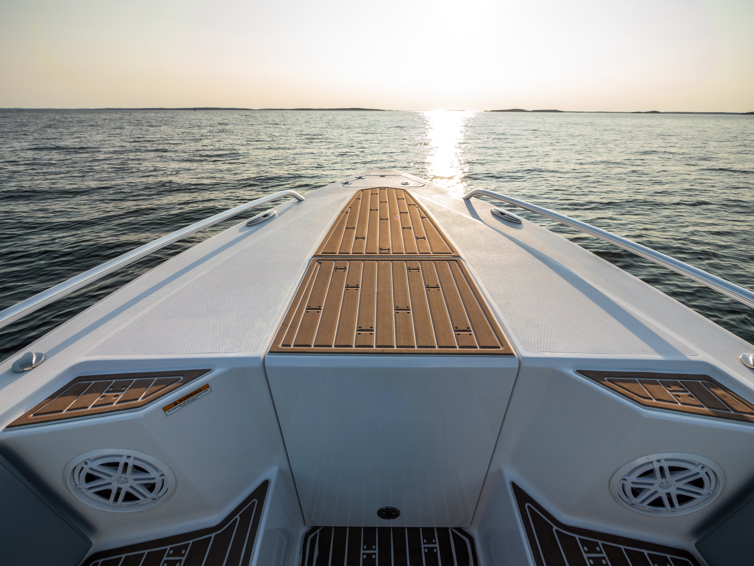 View from the front of a boat on the water during sunset.