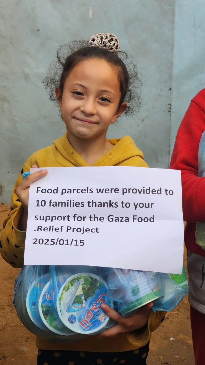 A young girl in a yellow hoodie holding a bag of food items and a sign that reads "Food parcels were provided to 10 families thanks to your support for the Gaza Food Relief Project. 2025/01/15."