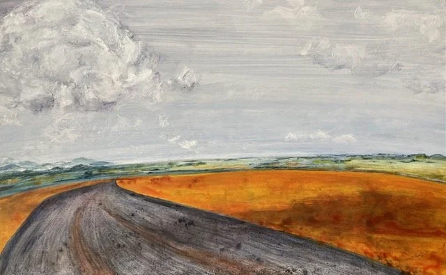 purple gray road crossing shadow-draped gold hill under stacked white clouds, with blue and green valley floor in the distance