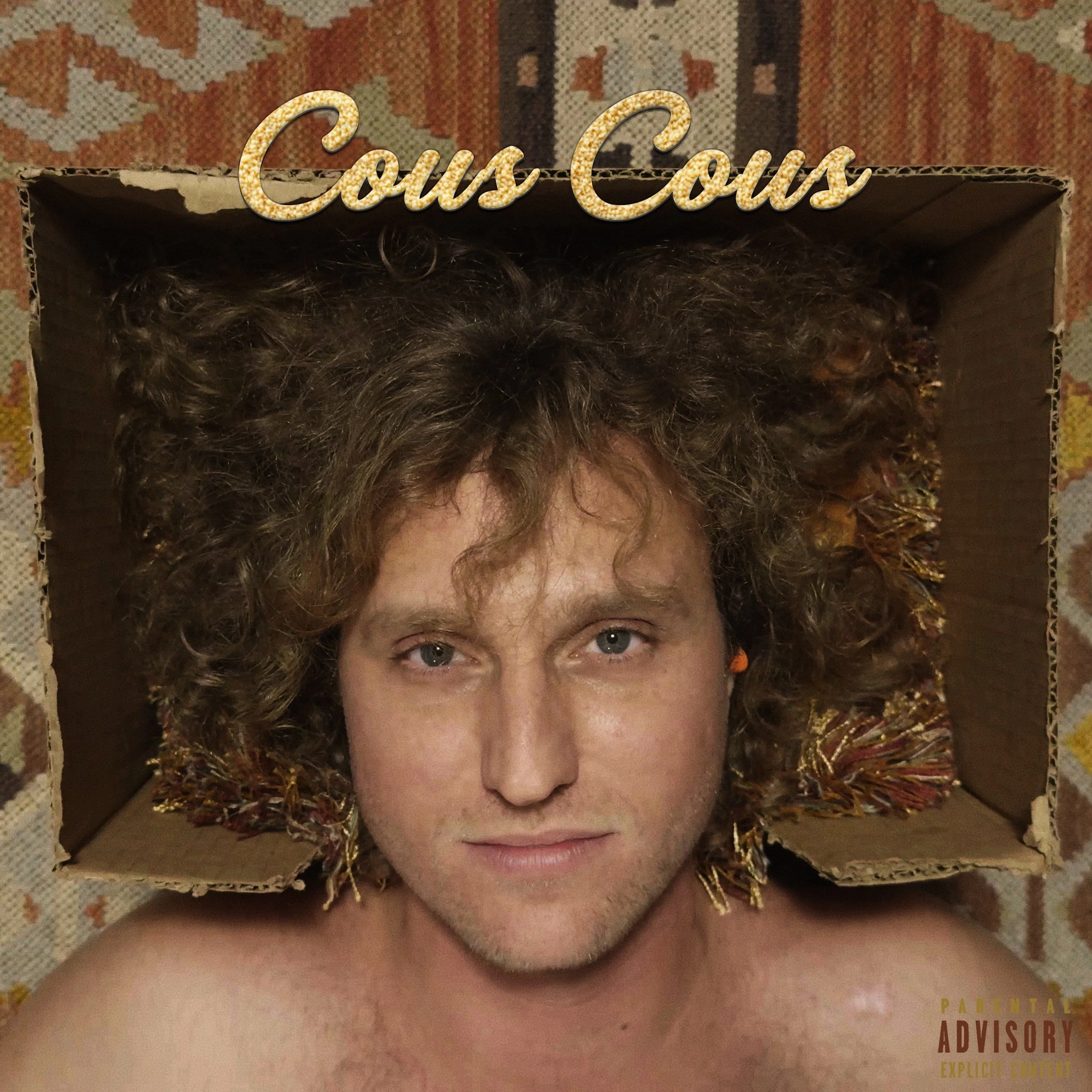 man lying down with head in cutout cardboard box with curly, dirty blonde hair