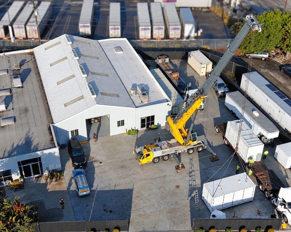 Aerial view of the Papadakis Engineering facility in Carson, California, with a crane and container in the yard.