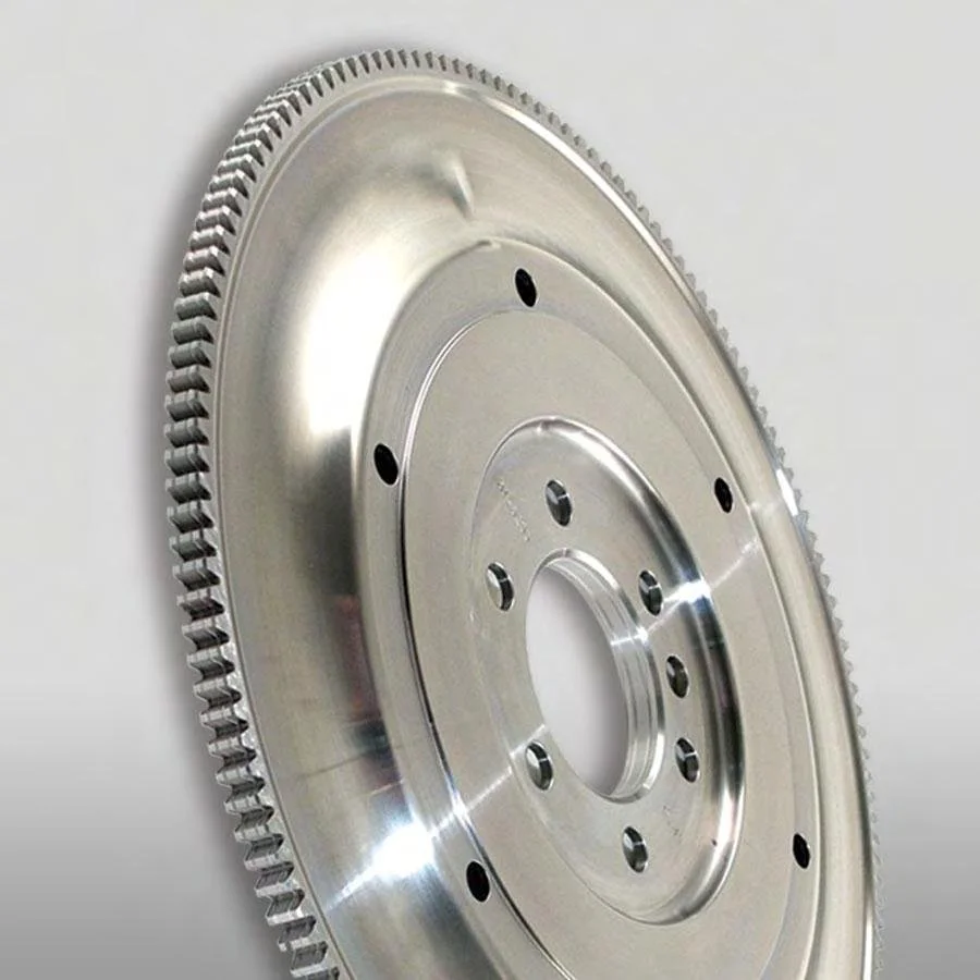 Machined automotive flywheel with a toothed ring gear, shown in close-up.