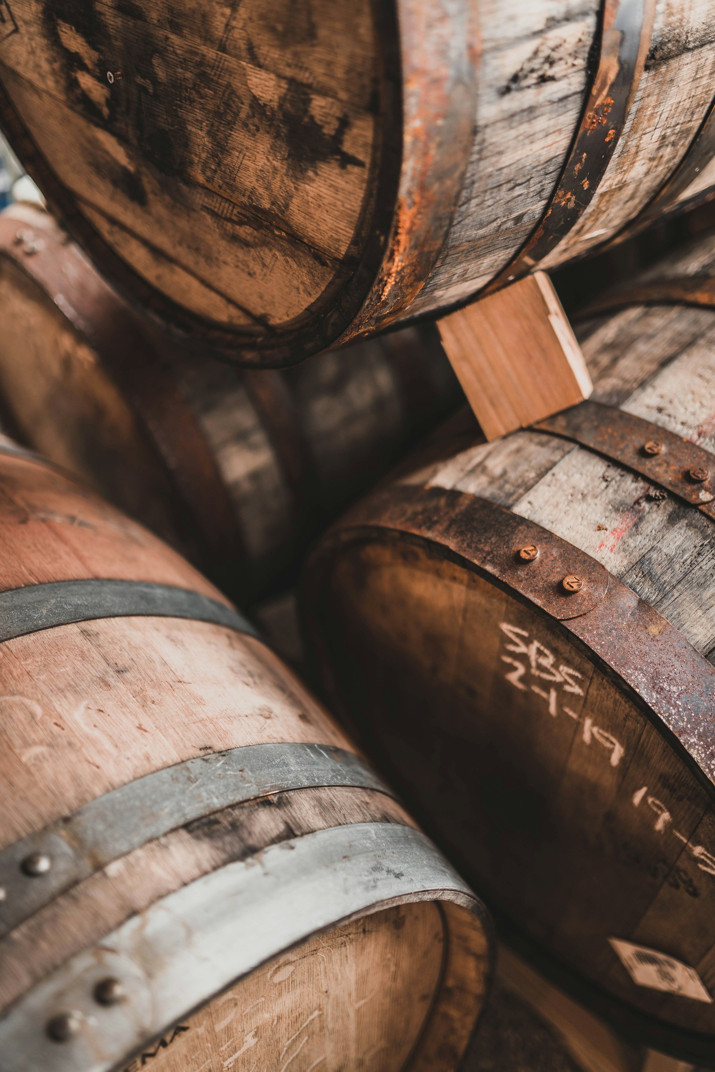 Close-up of stacked wooden barrels with metal bands, showing aged and weathered textures.