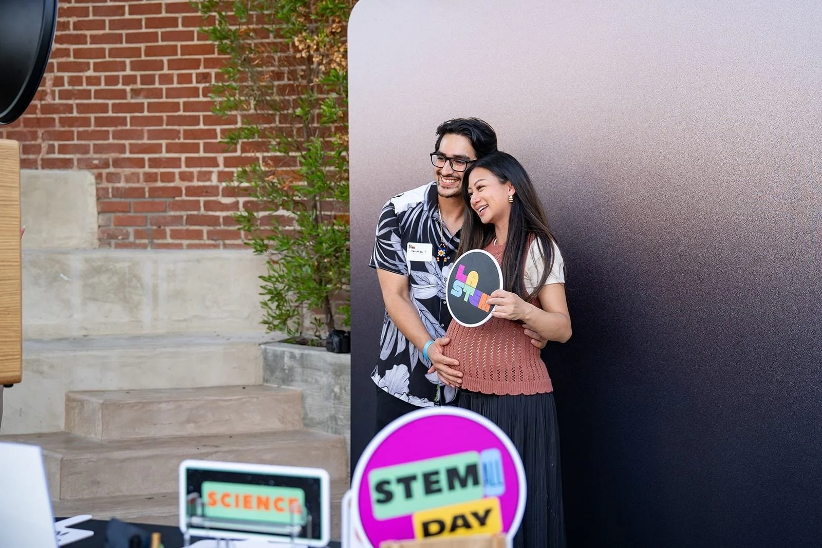 happy couple posing at corporate event photo booth custom props