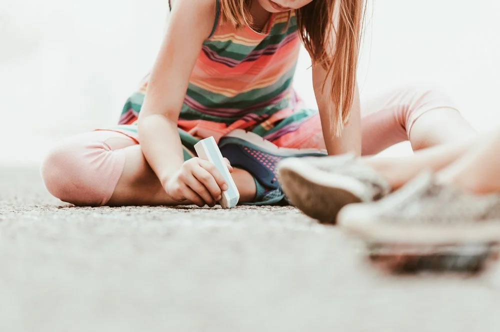 Barn som leker med en blå flygplansmodell på golvet.