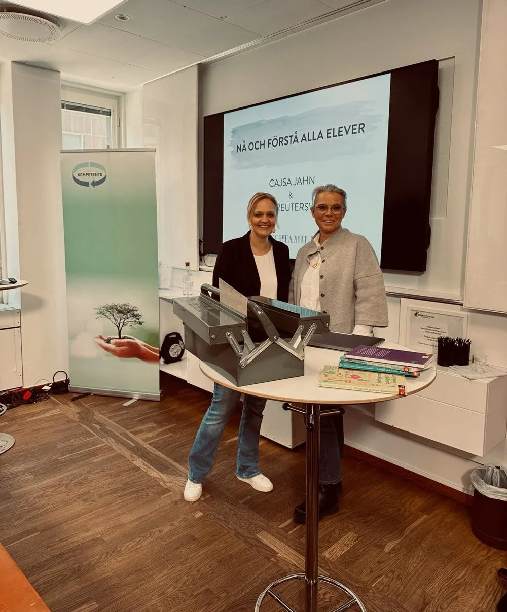 Två kvinnor står framför en stor skärm i ett konferensrum, en presenterar en presentation. En skylt med en träd och handen som håller ett moln finns till vänster.