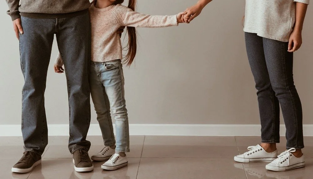 Barn som håller handen med en vuxen på en neutral bakgrund.