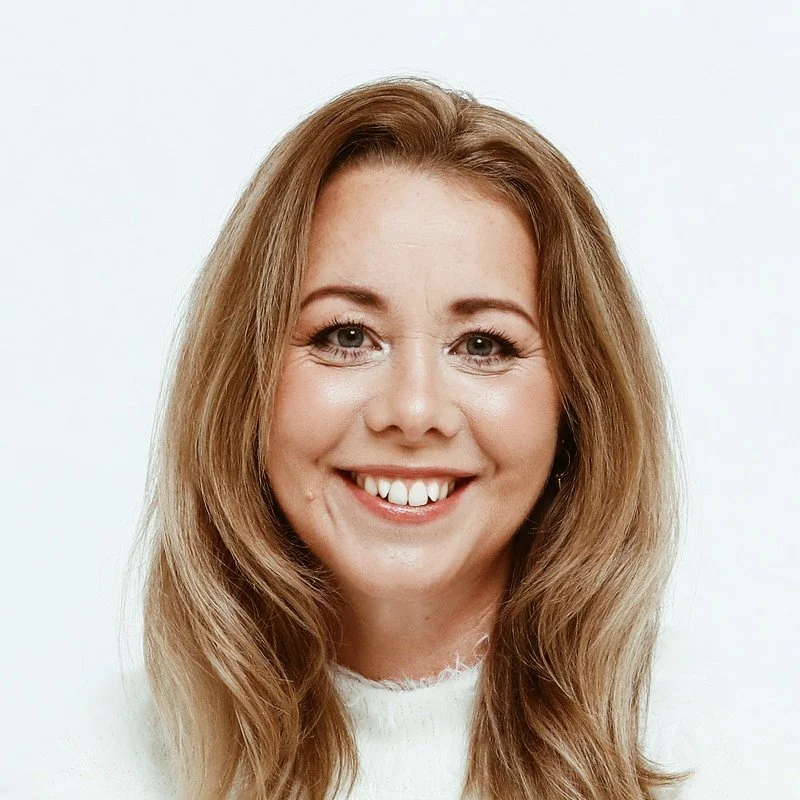 En leende kvinna med långt, ljust hår och vita tänder