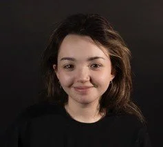 Person smiling against a dark background