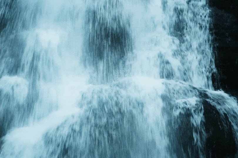 Ein Wasserfall mit fließendem Wasser, das über Steine stürzt. Jenny Schweiger, Schenewa, Emergenz