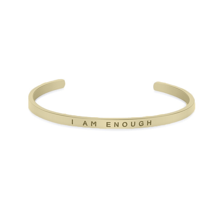 Beige cuff bracelet with engraved text that says 'I AM ENOUGH'
