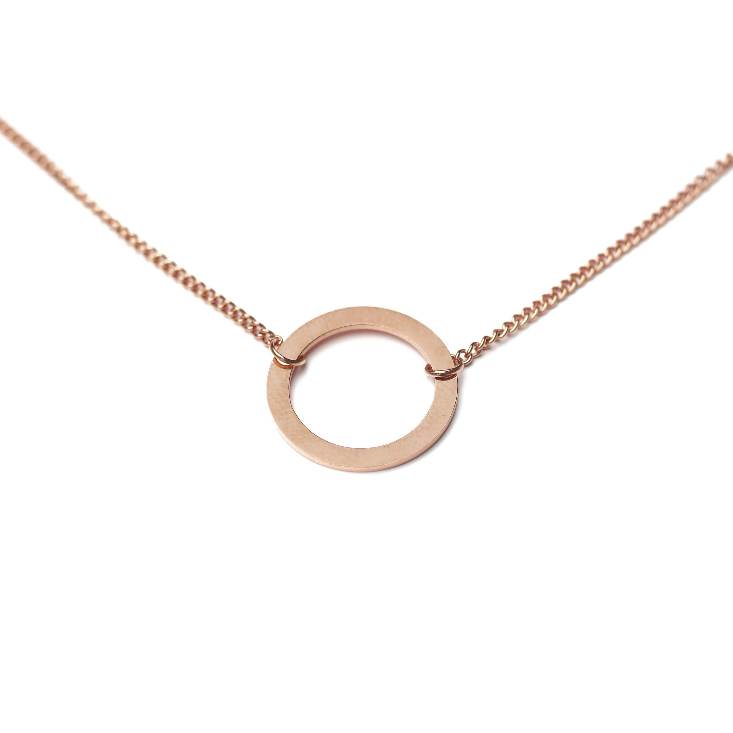 Rose gold necklace with a circular pendant on a white background.
