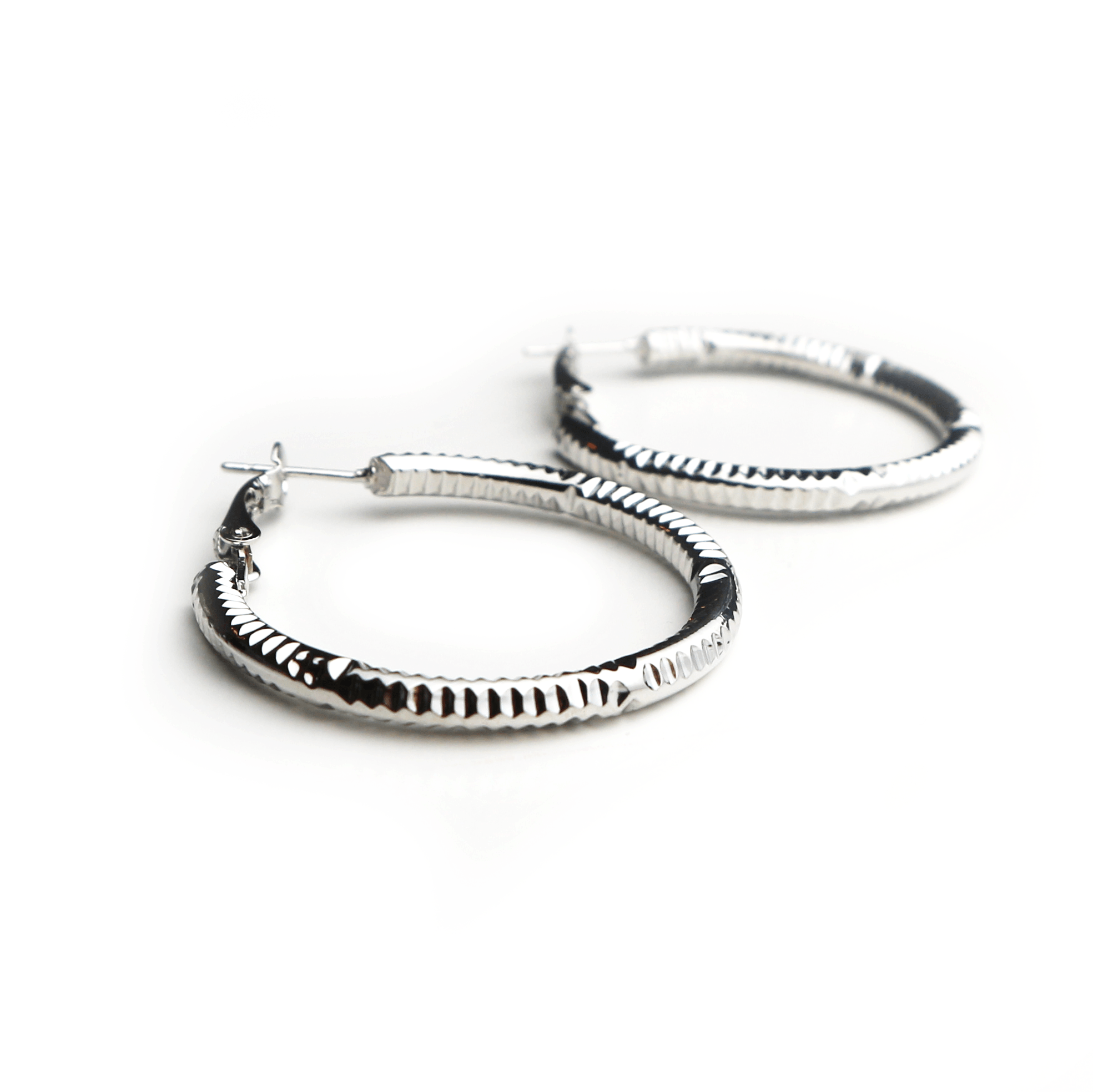 Silver hoop earrings with textured patterns on a white background.