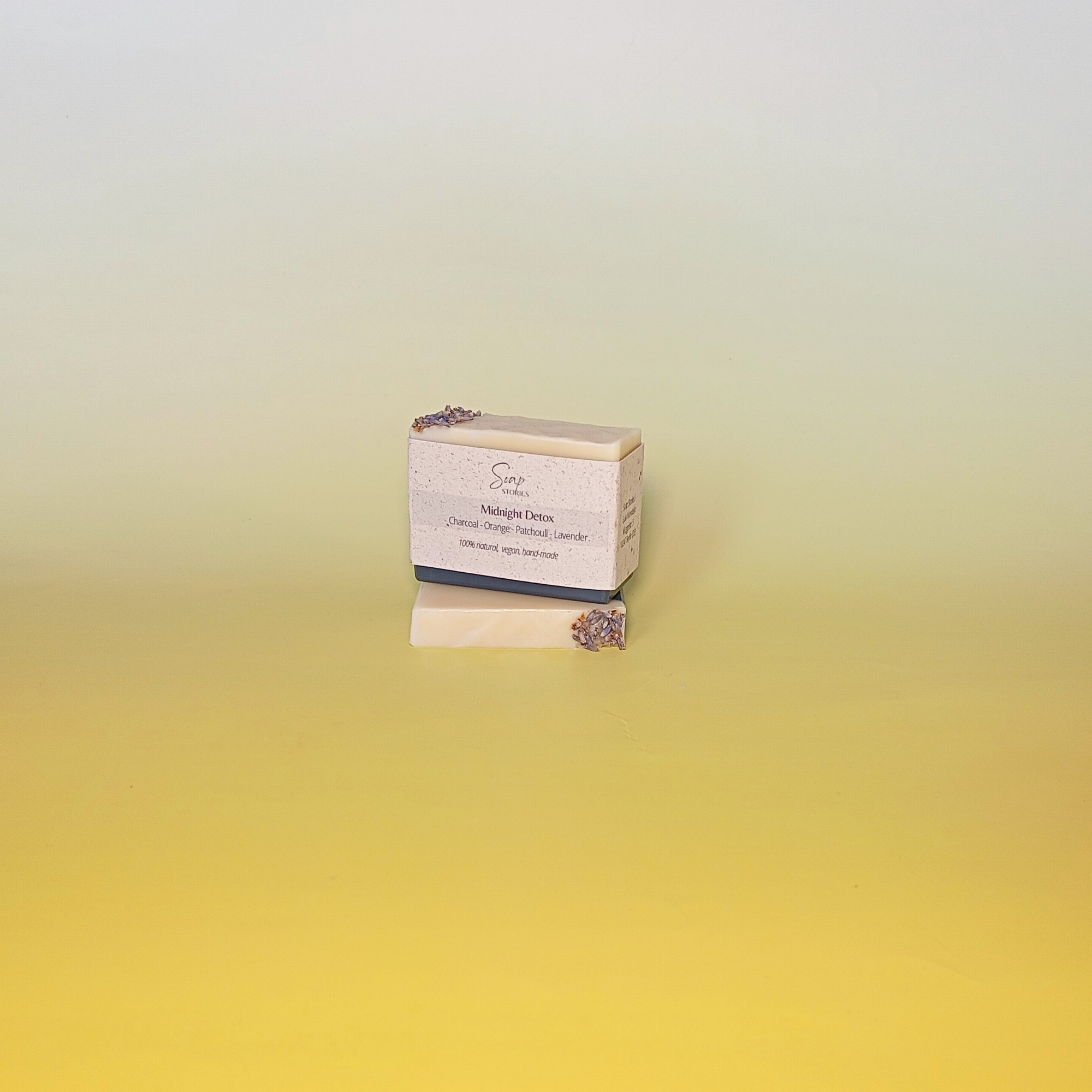 Handmade soap bar wrapped in a beige recycled paper sleeve with printed product name and details, showcasing eco-friendly and natural packaging design