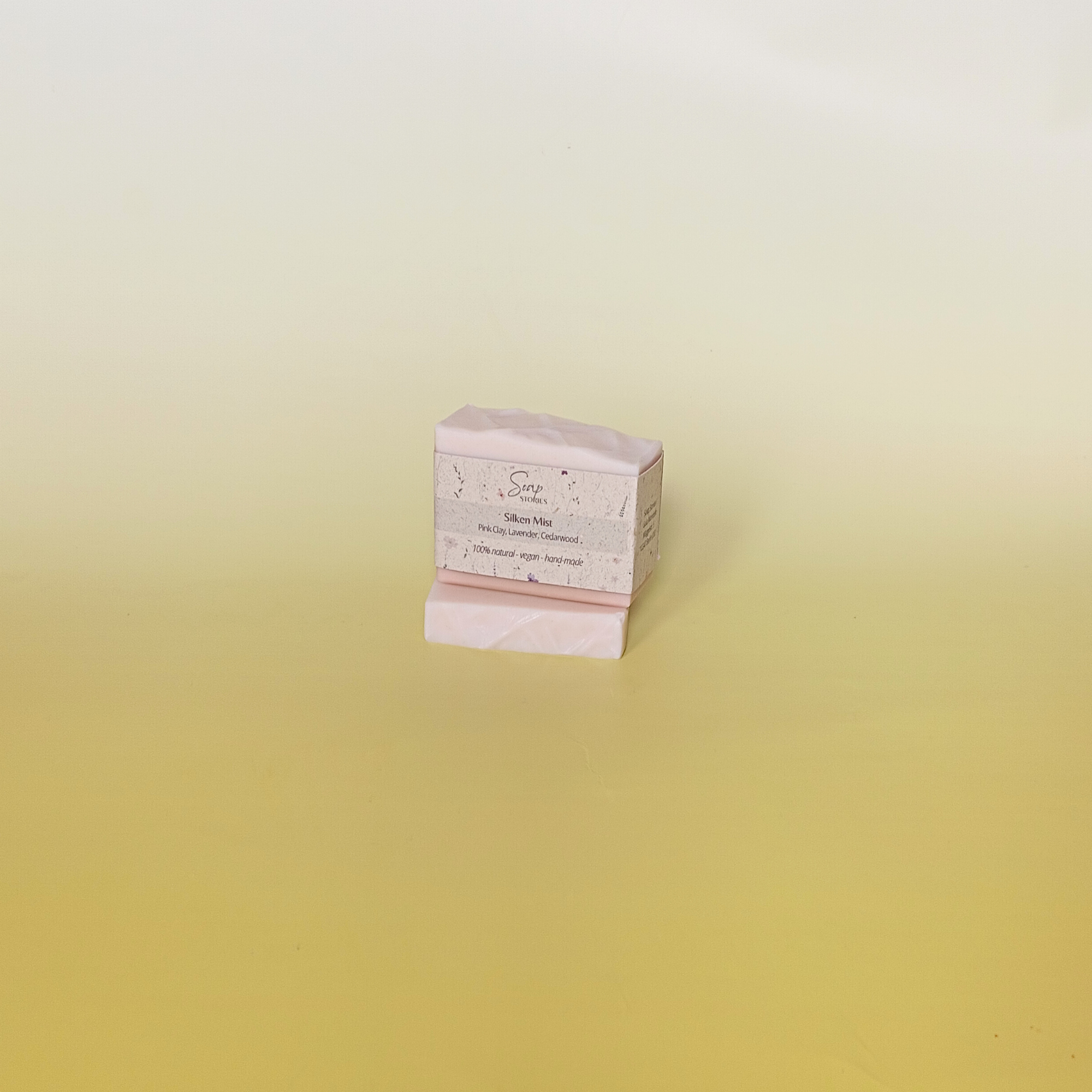 Handmade soap bar wrapped in a beige recycled paper sleeve featuring printed ingredients list and product information, highlighting sustainable and natural packaging