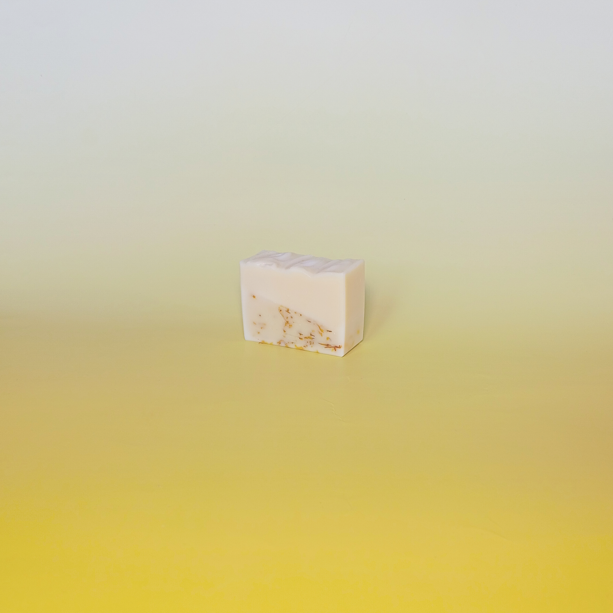 Handmade calendula soap bar wrapped in a beige recycled paper sleeve with printed product name and details, showcasing eco-friendly and natural packaging design