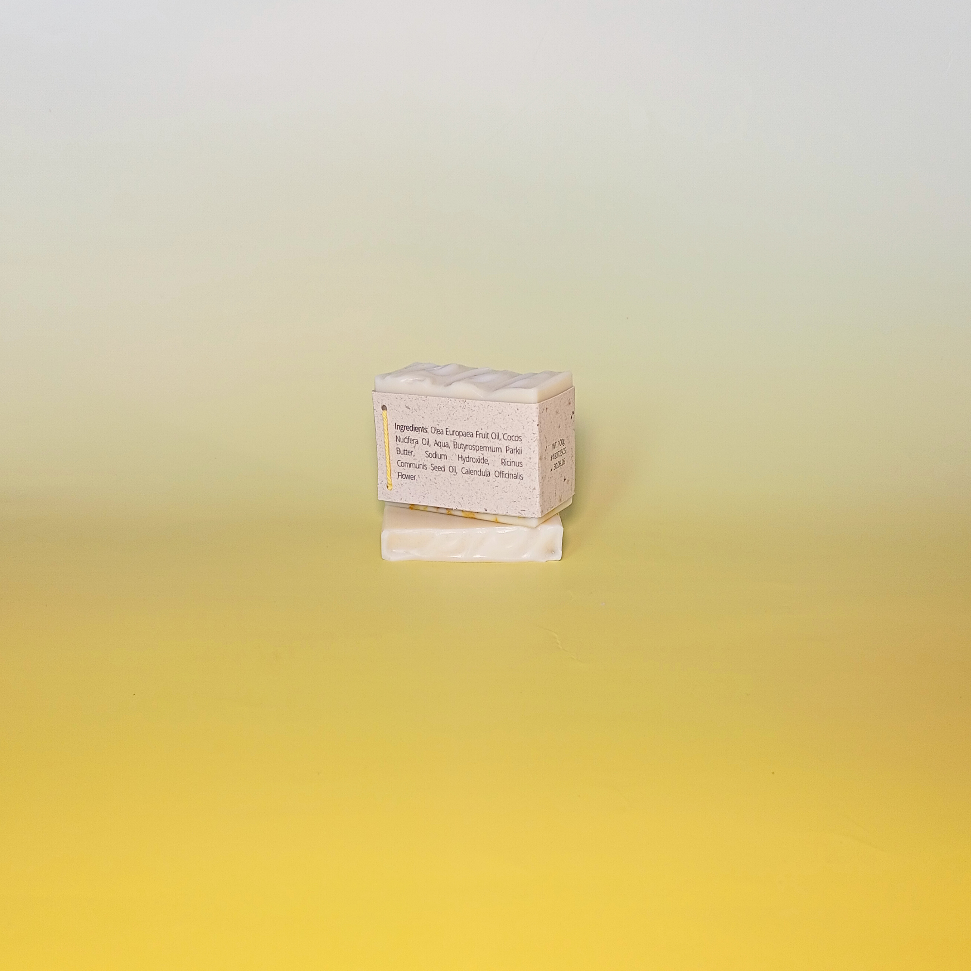 Handmade calendula soap bar wrapped in a beige recycled paper sleeve with printed product name and details, showcasing eco-friendly and natural packaging design