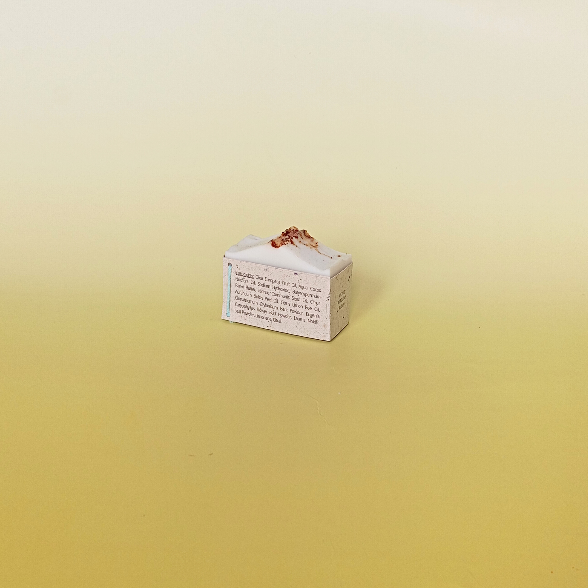 Two-tone natural soap bars with rich brown bases and creamy tops, artistically arranged on a soft yellow gradient background, highlighting a minimal and earthy design_with_natural_sleeve