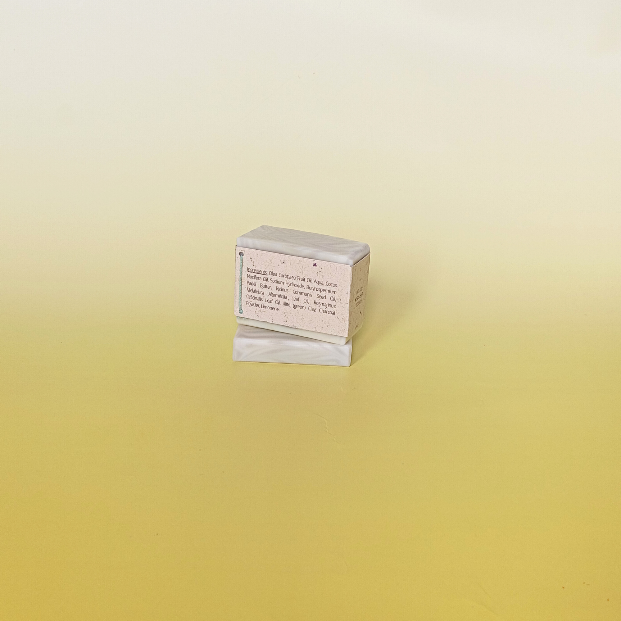 Handmade soap bar wrapped in a beige recycled paper sleeve with printed product name and details, showcasing eco-friendly and natural packaging design