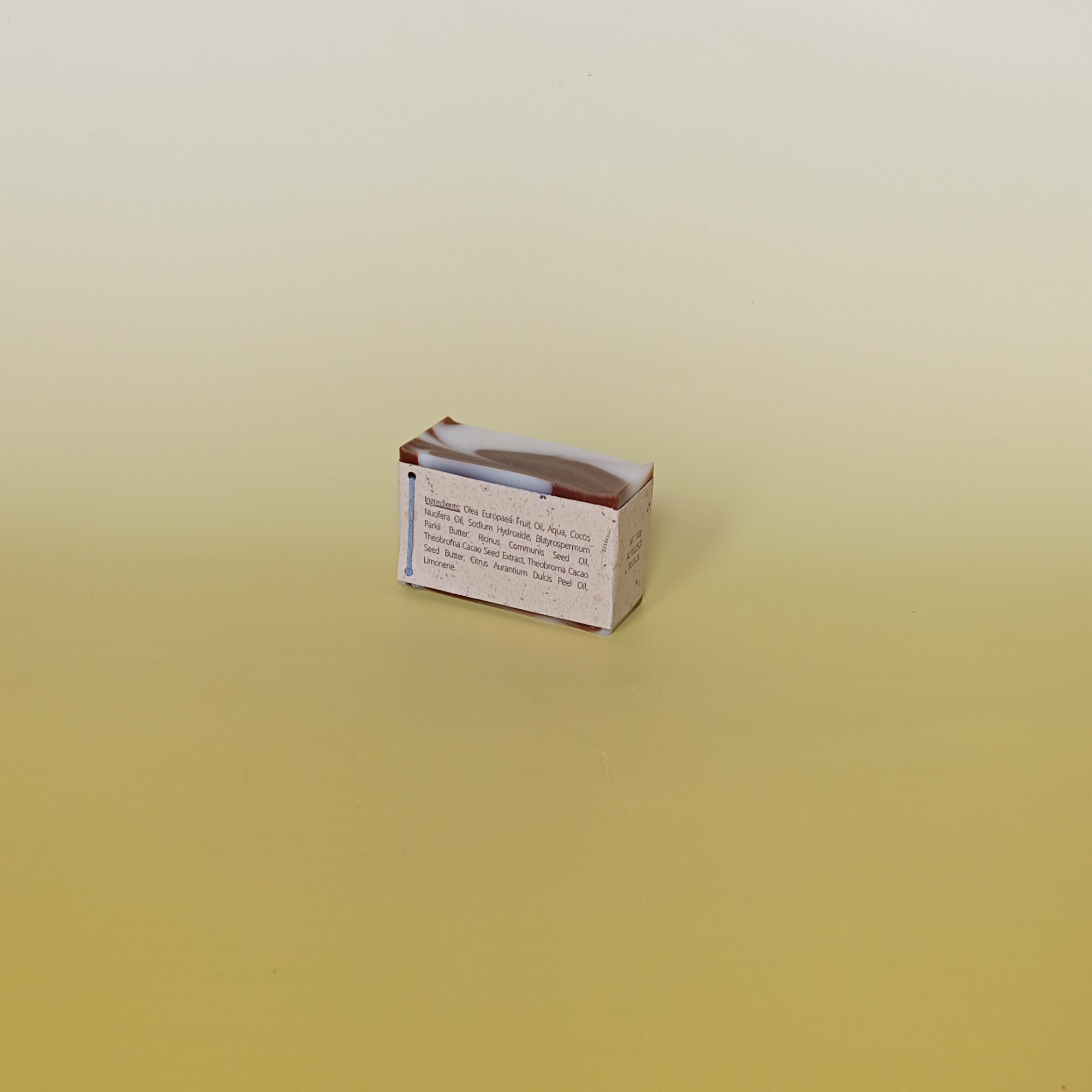 Handmade soap bar wrapped in a beige recycled paper sleeve with printed product name and details, showcasing eco-friendly and natural packaging design
