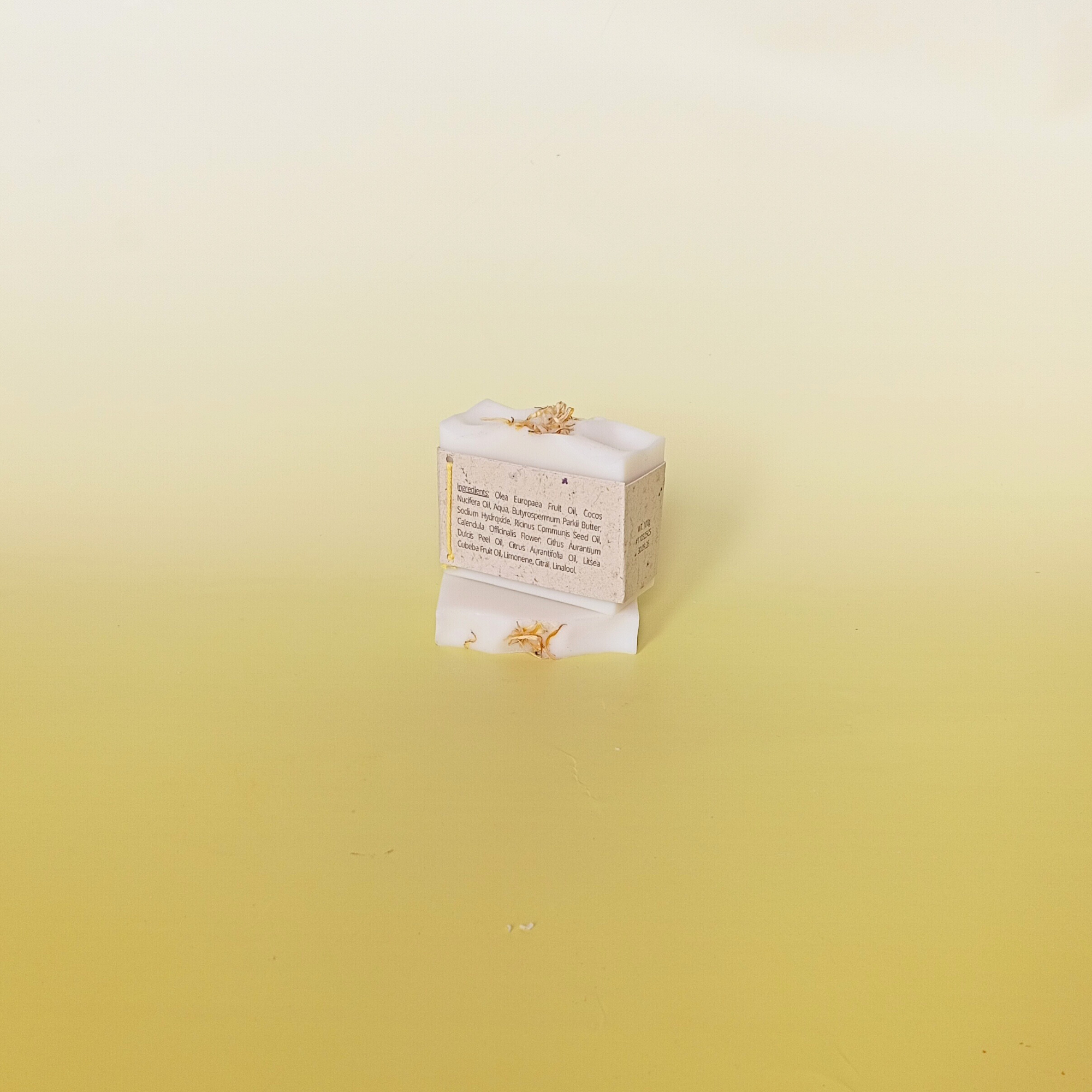 Handmade soap bar wrapped in a beige recycled paper sleeve with printed product name and details, showcasing eco-friendly and natural packaging design