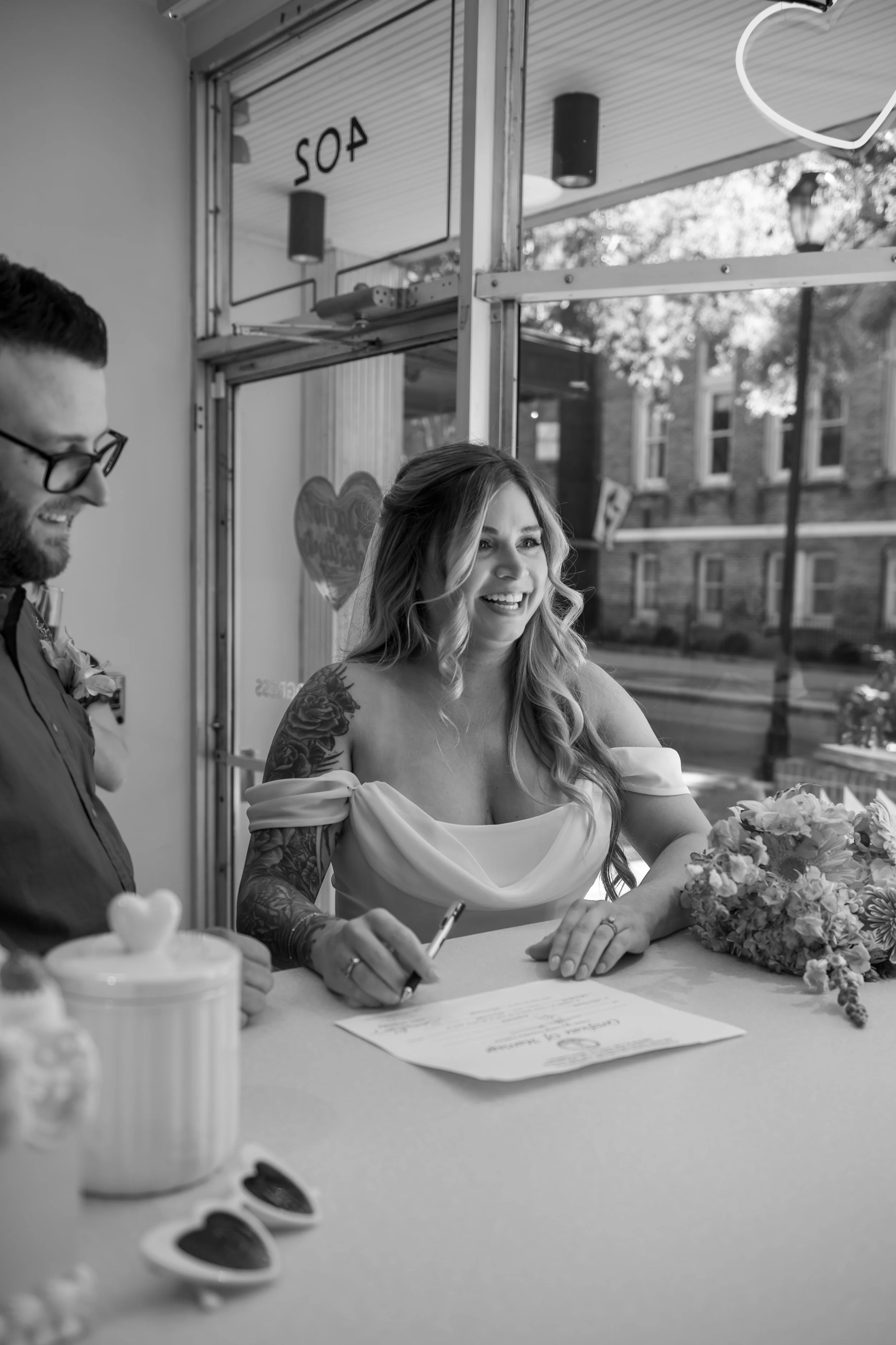 A couple standing at the desk of Lucky In Love Chapel signing their marriage license 
