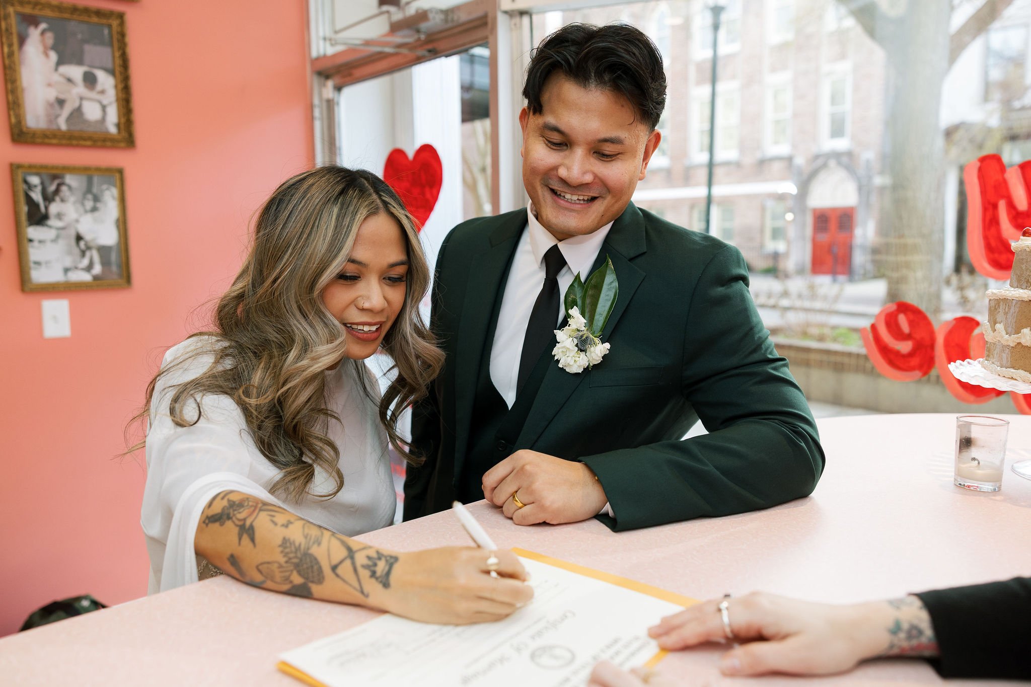 Couple signing their marriage license at the desk of lucky in love chapel