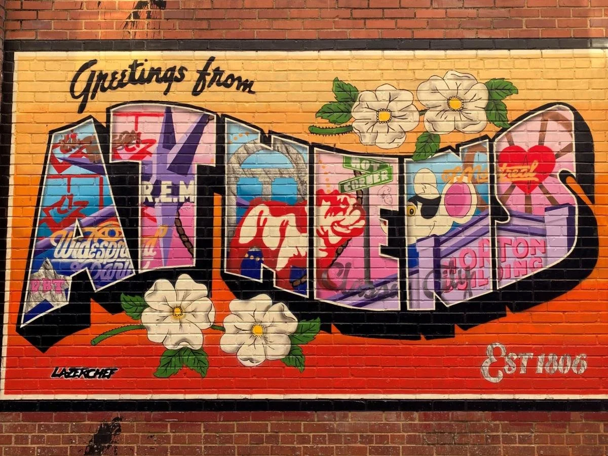 Colorful graffiti art on a brick wall spelling out 'LOVE' with floral decorations and various street art symbols.