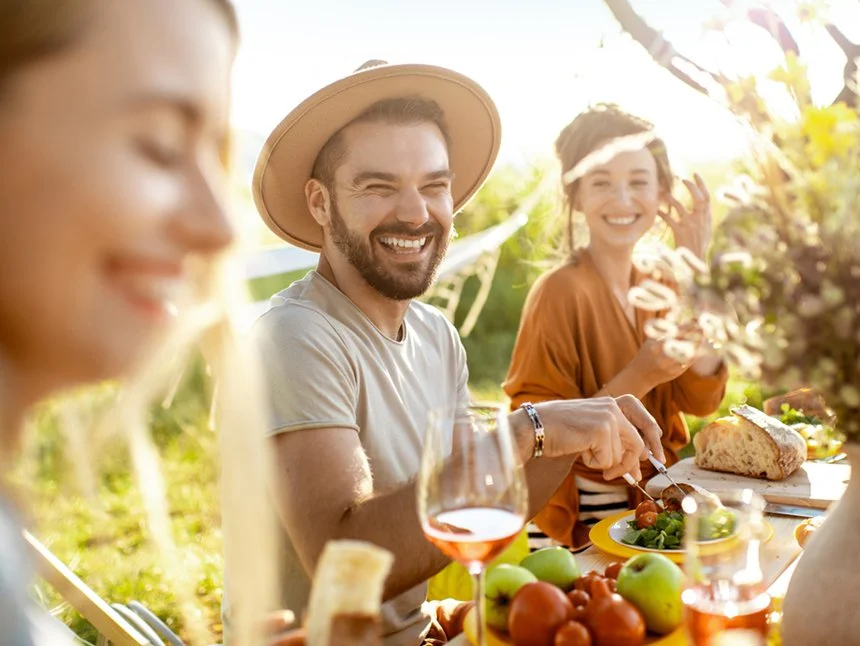 Group of energetic young friends having a gourmet meal outdoors