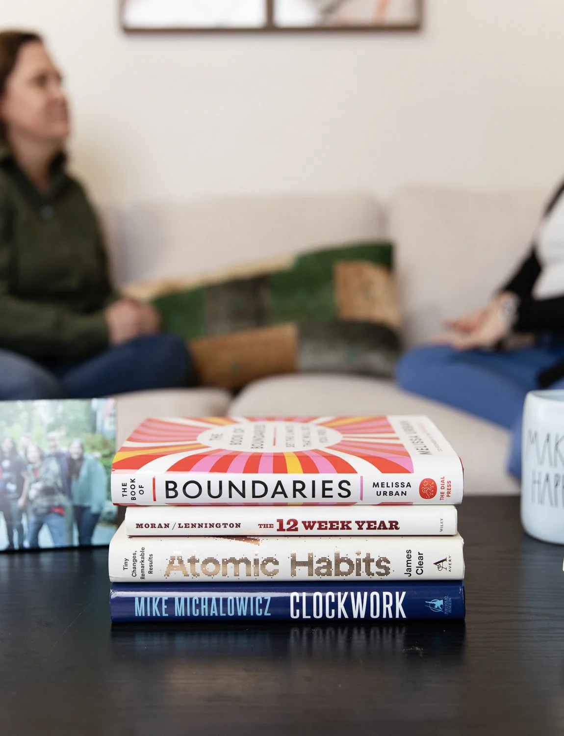 Stack of books on entrepreneurship on a table with Kathleen in the background