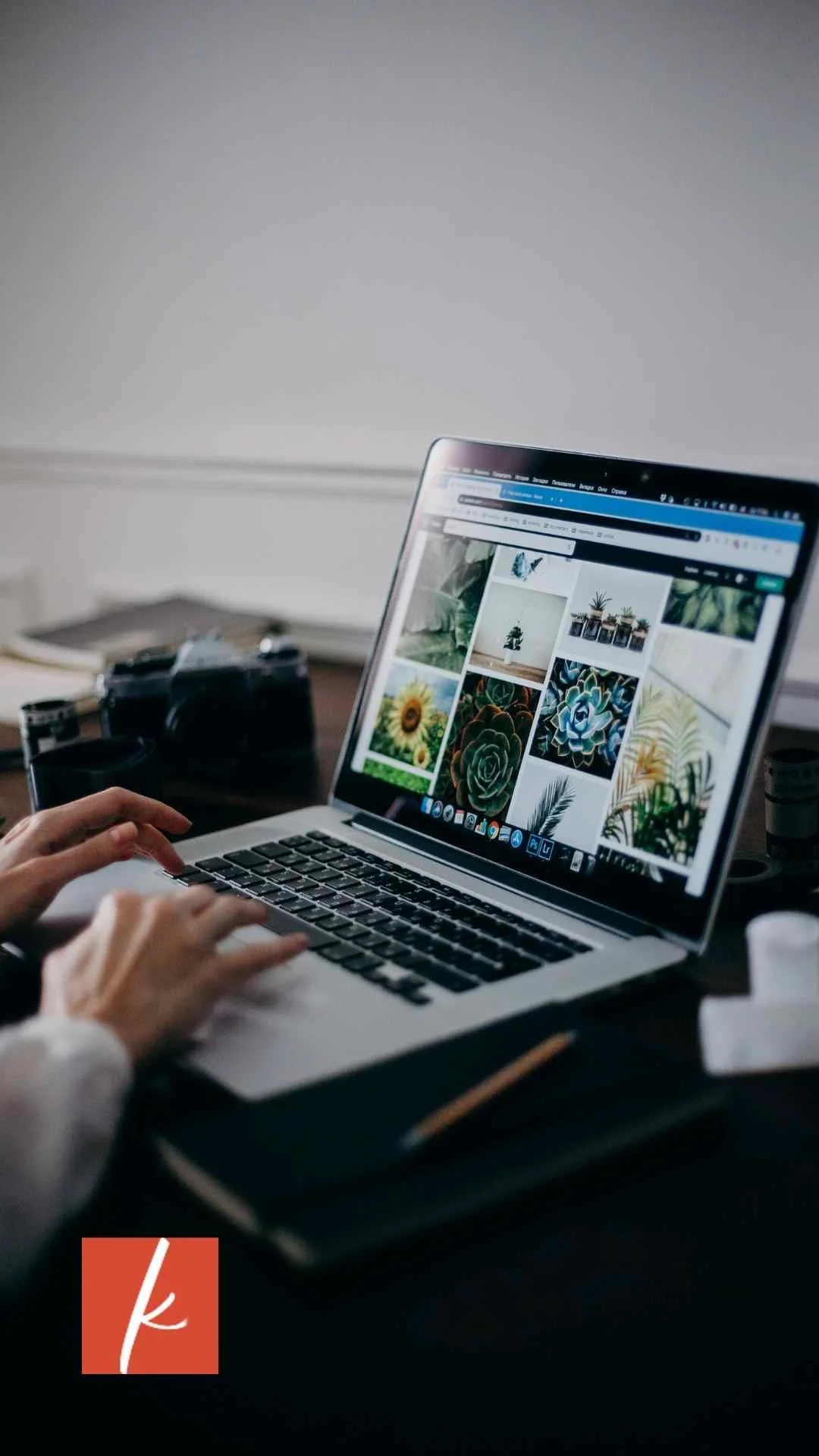 Laptop screen showing a visual content grid as someone types, representing digital marketing or website work.