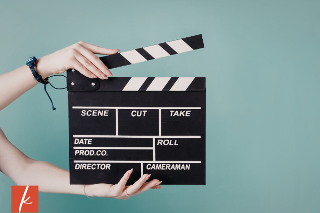 arms and hands using a clapperboard in front of a blue background