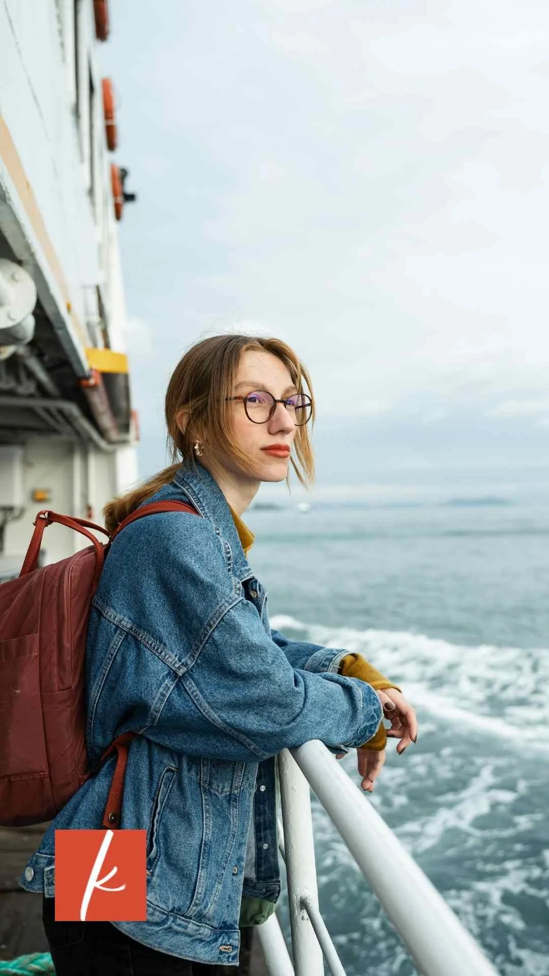 Woman standing on a boat looking out over the water.