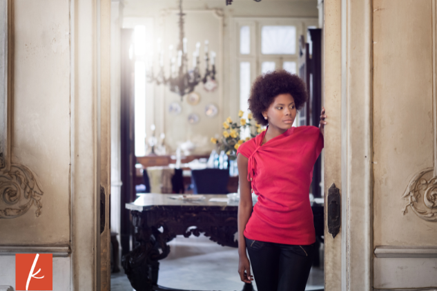 Woman in a red top looking into hallway from the doorway