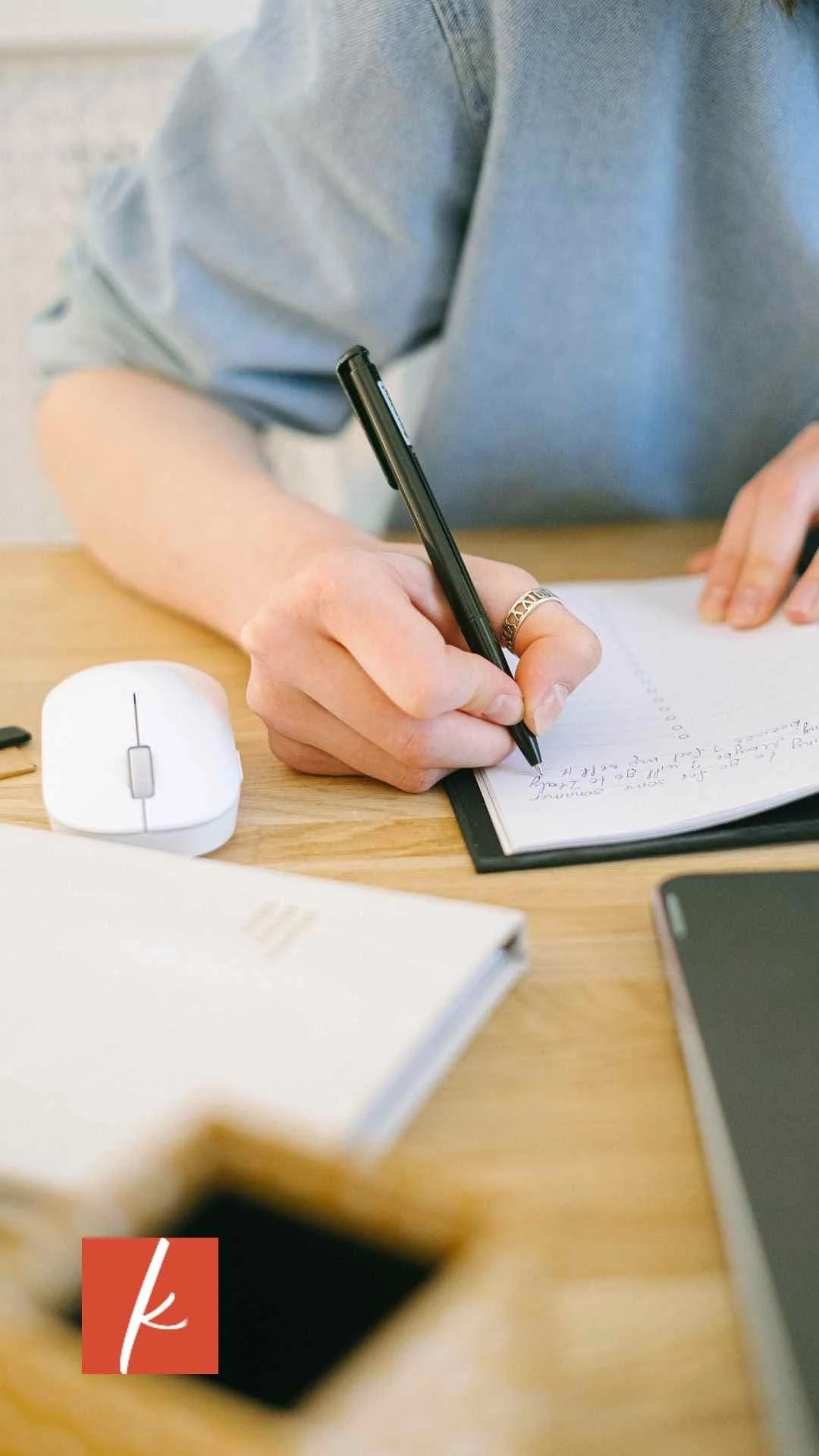 Close-up of a person writing in a notebook with a pen