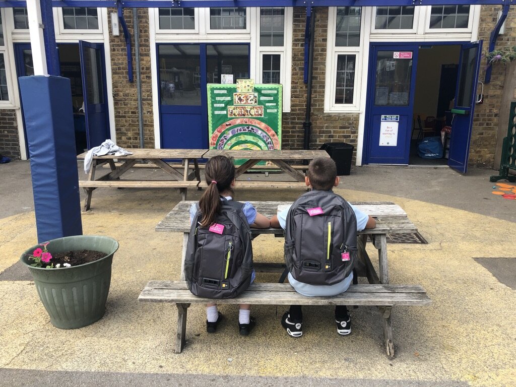 children sitting at a bench at school