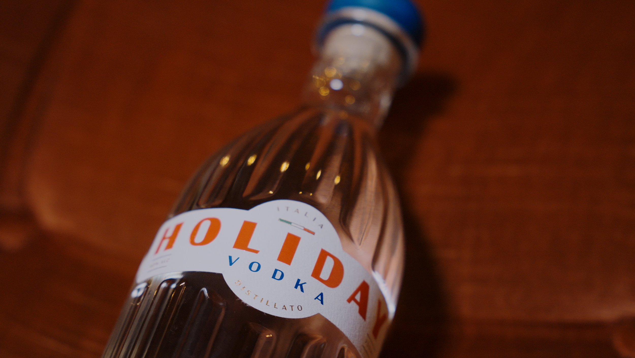 Close-up of a liquor bottle with a white label reading "Hot Vodka" and a wooden surface background.