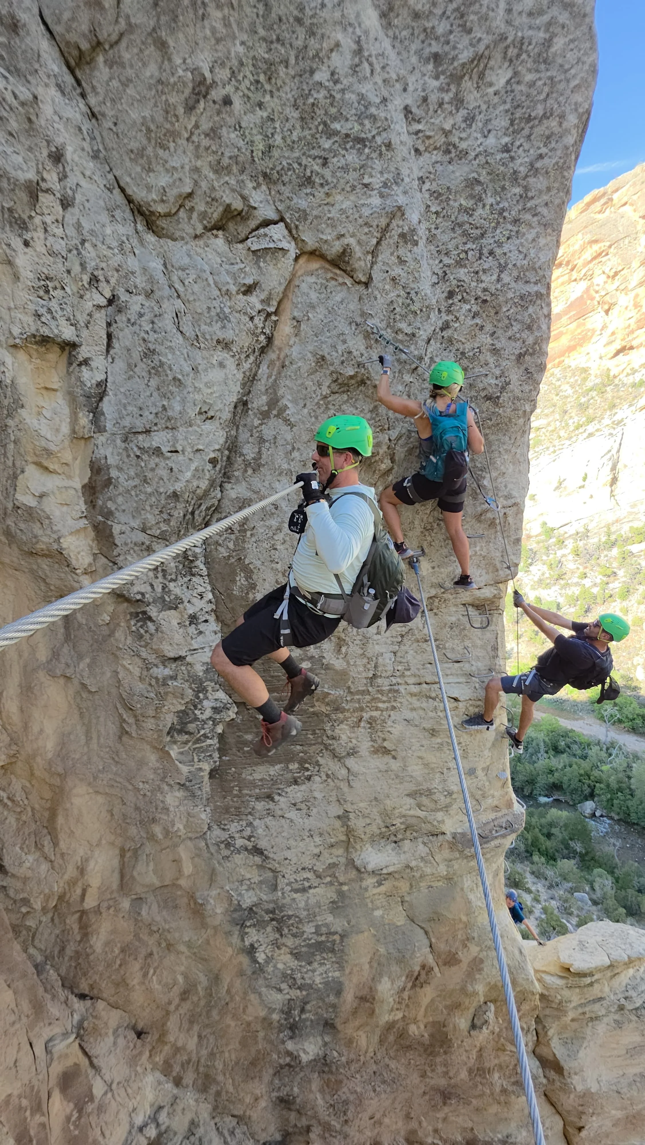 Fixed bridge spanning an exposed section of the Ashley Gorge route. Climbers crossing a constructed bridge between sandstone walls.