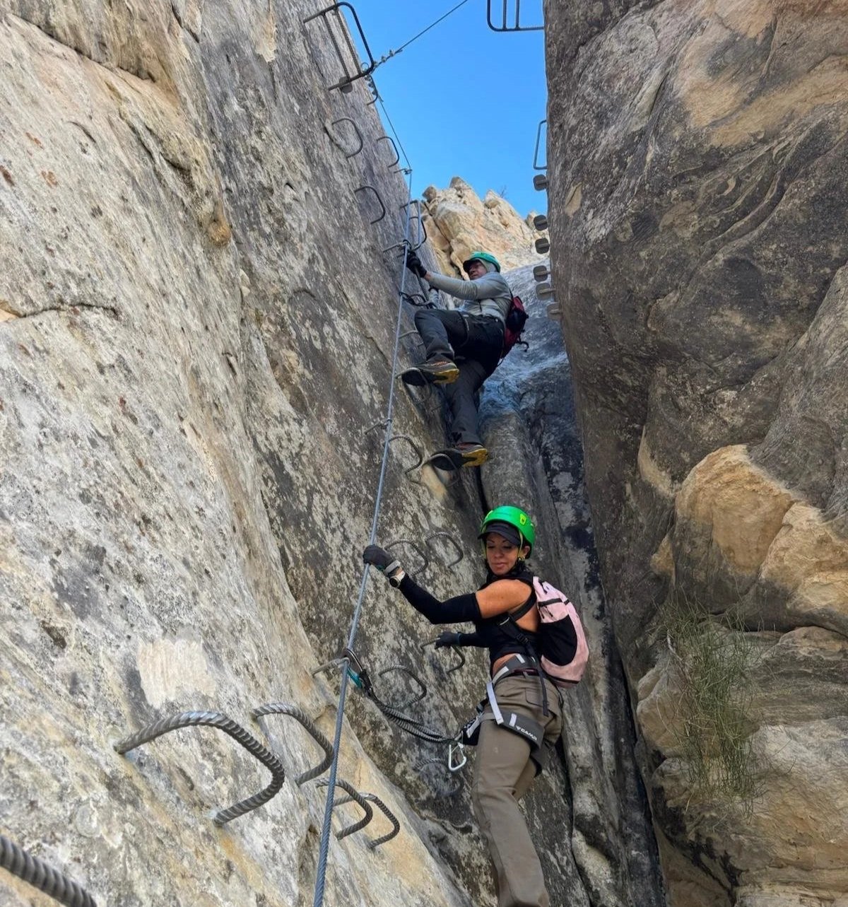 Guided climbers using fixed rungs and via ferrata gear on a beginner-friendly adventure in Vernal Utah.